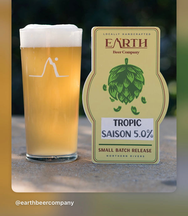 Freshly poured Tropic Saison Belgian Farmhouse Ale in a beer glass brewed from the award-winning Border Brewing All Grain Recipe Kit.