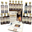 Still Spirits Whiskey Flavouring Craft Kit with bottles and recipe book on a reflective surface