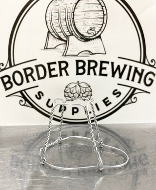 Champagne Wire Cage Made in Italy Known in French as a muselet or muzzle, the wire cage that holds a Champagne or sparkling wine cork in place is very important in opening a bottle of bubbly safely. The muzzle should not be removed before the cork is eased out